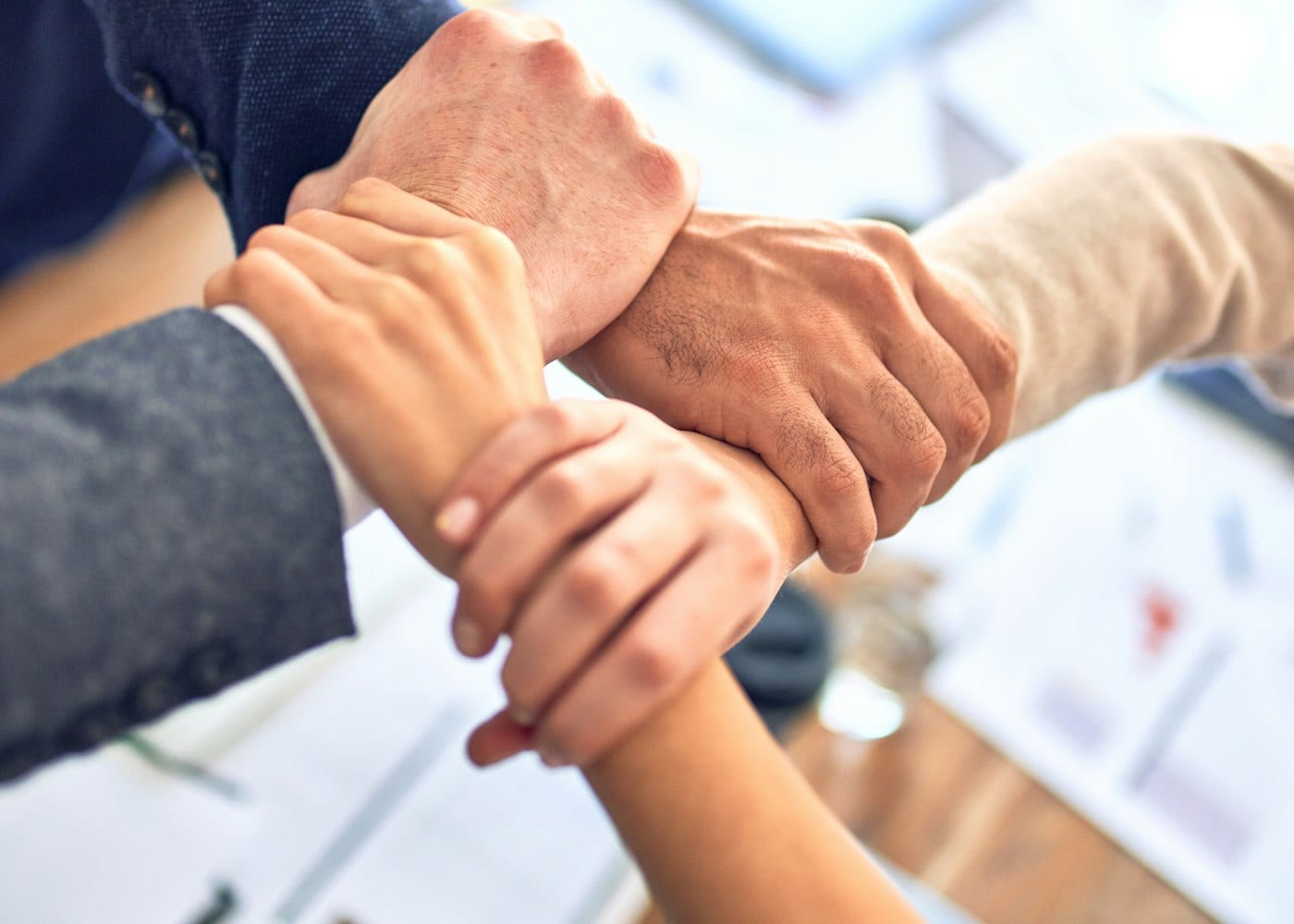 Colleagues joining hands as a team