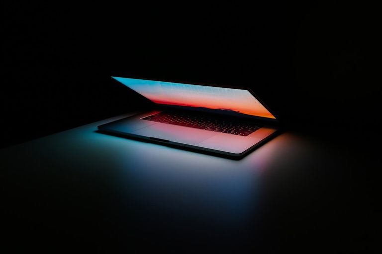 Laptop computer glowing against a dark background