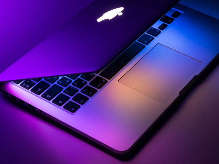 Laptop keyboard lit with purple and blue light